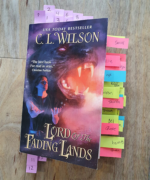 Paperback of Lord of the Fading Lands by C.L. Wilson with a ton of mini post-it notes bookmarking various places of the book. The post-it notes have handwritten labels (not all clearly legible though). Some of the labels are "Sariel", "Tairen", "Threat", "Quote".