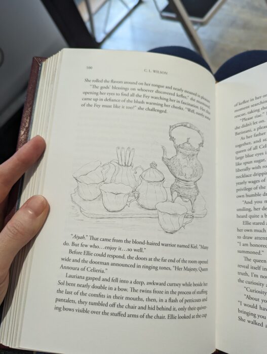 Photo of the interior page of a book. In between the paragraphs if a rough sketch of what looks to be a tea or coffee set. There's an intricate pot and delicate cups.